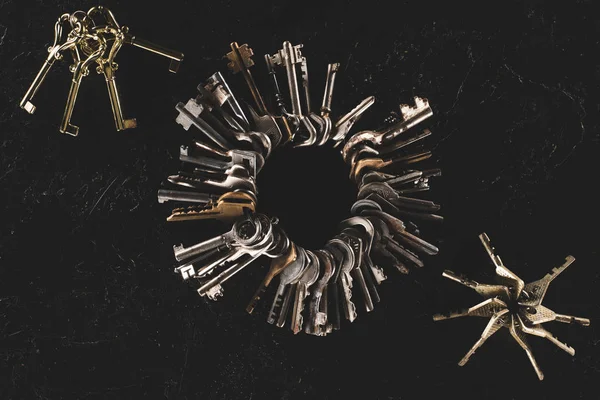 Top view bunches of different keys on black table — Stock Photo