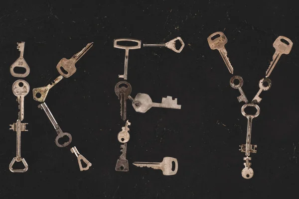 Top view of metal keys forming word on black table — Stock Photo