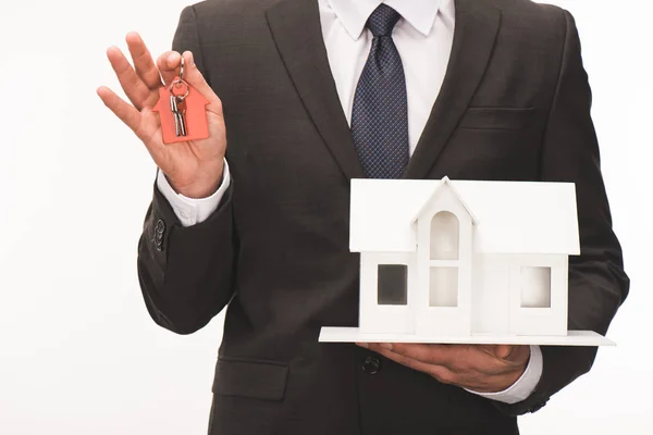 Imagem cortada de homem segurando maquete de casa com chave isolada em branco — Fotografia de Stock