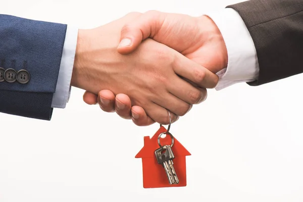 Cropped image of shaking hands with key from house isolated on white — Stock Photo