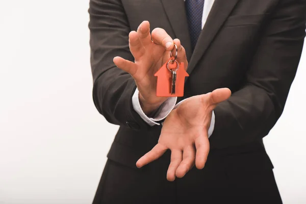 Cropped image of man holding key from house isolated on white — Stock Photo
