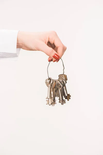 Cropped image of female hand holding keys isolated on white — Stock Photo