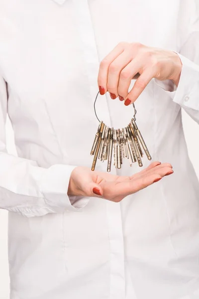 Обрізане зображення жіночих ключів, що тримають ізольовані на білому — стокове фото