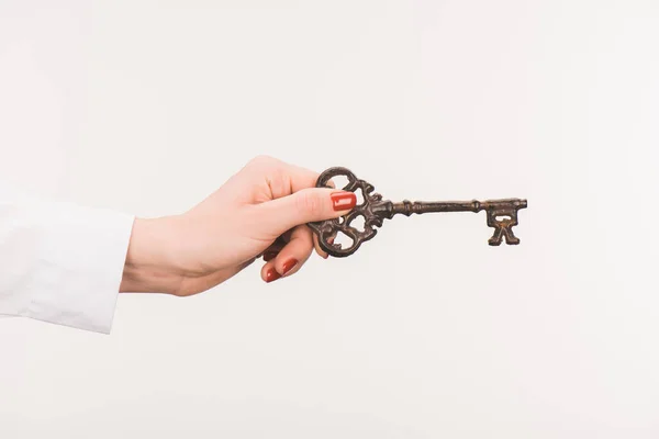 Cropped image of female hand holding vintage key isolated on white — Stock Photo