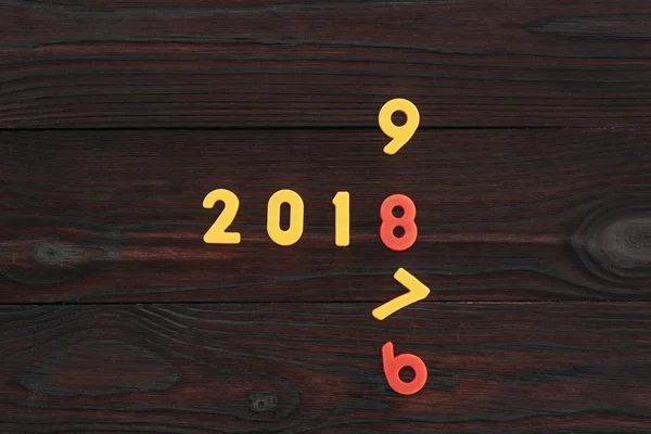 Vista dall'alto dei numeri colorati 2018 sulla superficie di legno scuro — Foto stock