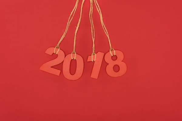 Nahaufnahme des Jahres 2018 Schild hängt an Fäden isoliert auf rot — Stockfoto