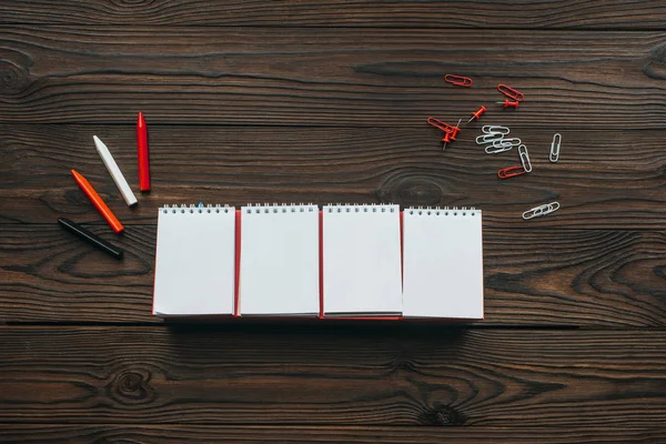 Vista dall'alto di calendario bianco organizzato, matite, clip e spilli su tavolo in legno — Foto stock