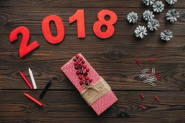 Flache Liege mit Weihnachtsgeschenken, Tannenzapfen und Jahresschild 2018 auf dunkler Holzplatte — Stockfoto