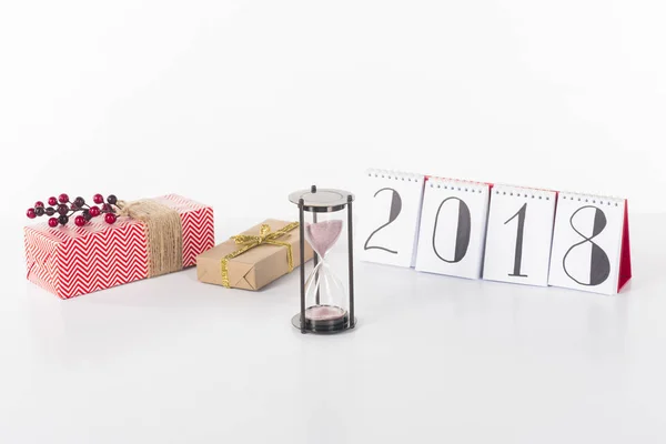Close up view of blank calendar, sand clock and wrapped gifts isolated on white — Stock Photo
