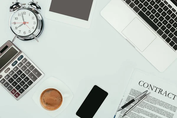 Vista superior de laptop, smartphone, contrato com canetas, despertador e calculadora em branco — Fotografia de Stock