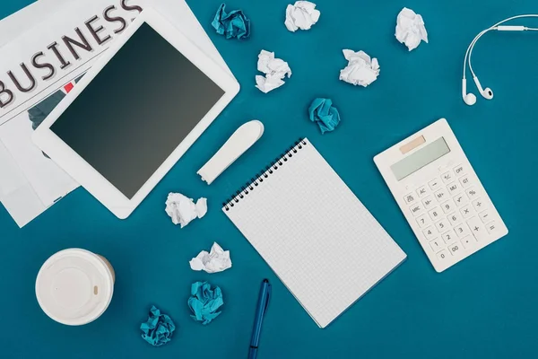 Top view of newspaper, digital tablet with blank screen, blank notebook and calculator on blue — Stock Photo