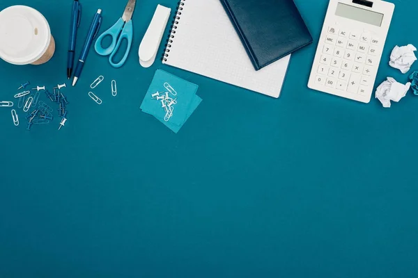 Vista superior da calculadora, café para ir e material de escritório em azul — Fotografia de Stock