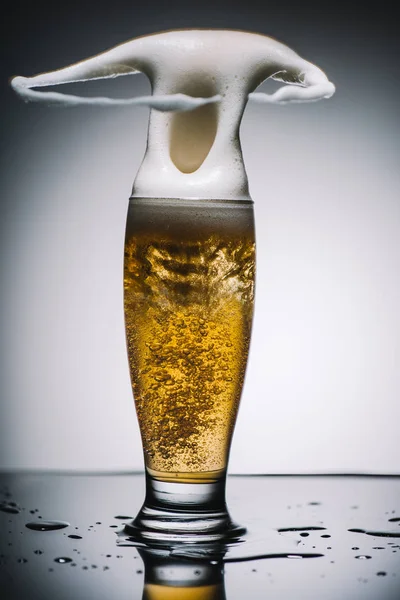 Espuma salpicante de cerveza ligera fresca — Stock Photo
