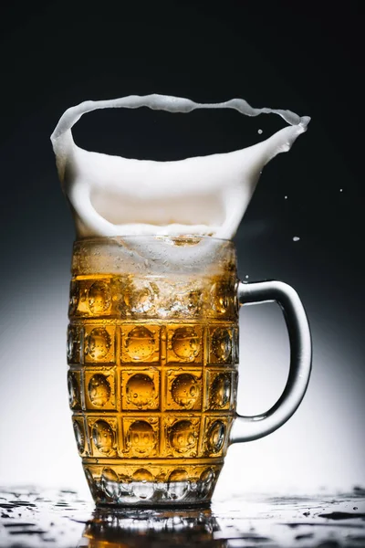 Всплеск пены из пинты золотого свежего пива — стоковое фото