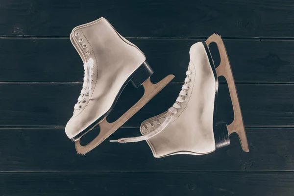 Vue de dessus de la paire de patins blancs sur une surface en bois rayé — Photo de stock
