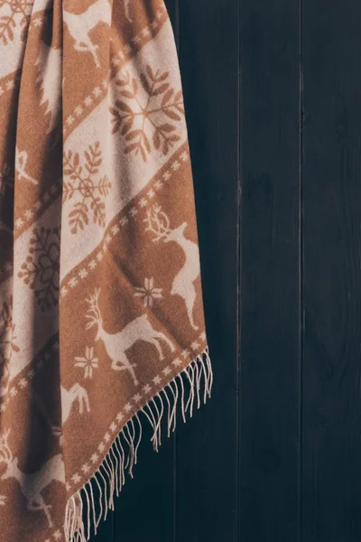 Warm scarf with deer and snowflakes ornament hanging on wall — Stock Photo