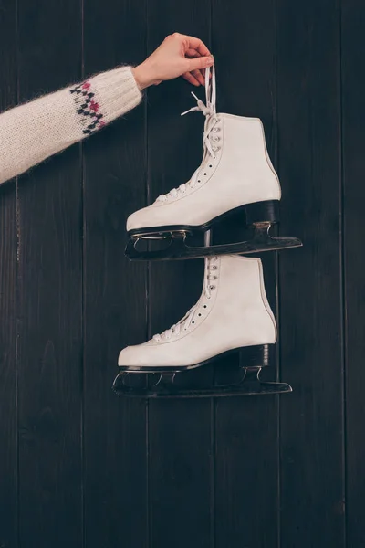 Imagem cortada de mulher segurando par de patins brancos em cinza — Fotografia de Stock