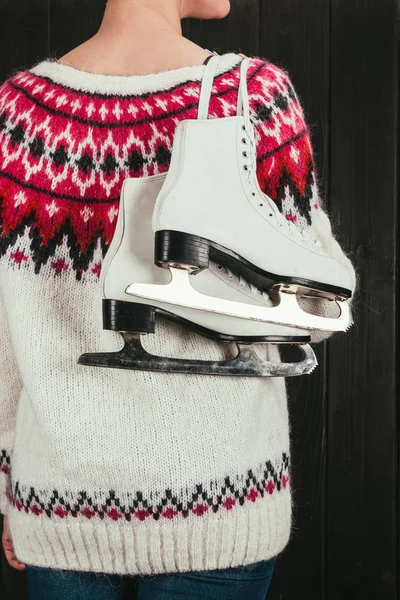 Cropped image of woman standing with white skates hanging on shoulder — Stock Photo