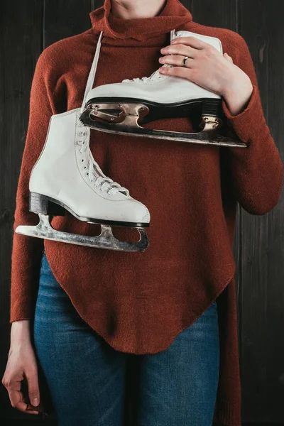 Imagen recortada de la mujer de pie con patines colgando en el cuello - foto de stock