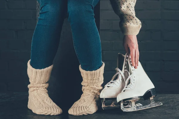 Imagen recortada de la mujer tomando patines del suelo - foto de stock