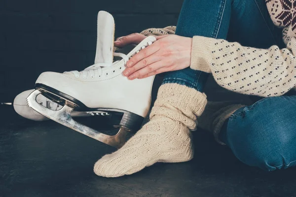 Cropped image of woman sitting and wearing white skates — Stock Photo