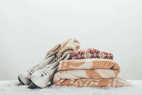 Pattini bianchi con pile di coperta e maglione sulla neve — Foto stock