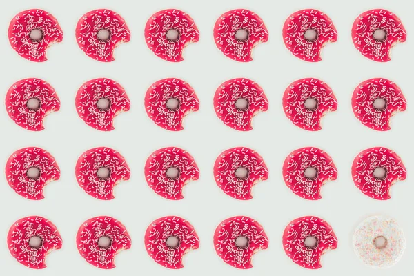 Vue de dessus des beignets vitrés roses motif sans couture isolé sur blanc — Photo de stock