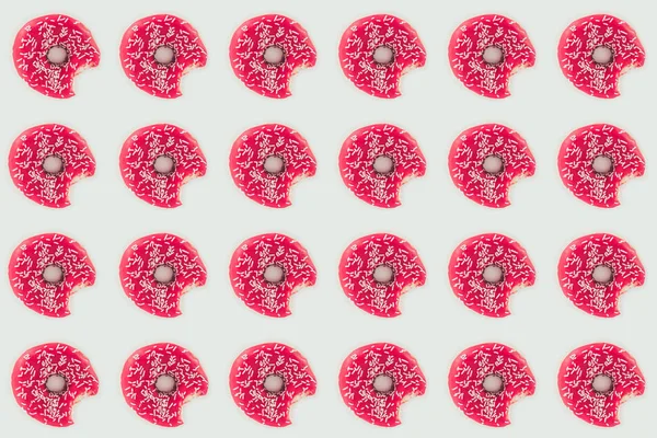Vista superior de rosquillas rosadas mordidas patrón sin costura aislado en blanco - foto de stock