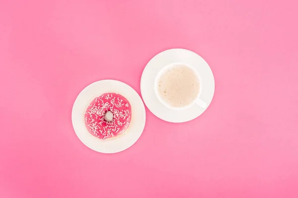 Top view of doughnut with cup of coffee isolated on pink — Stock Photo