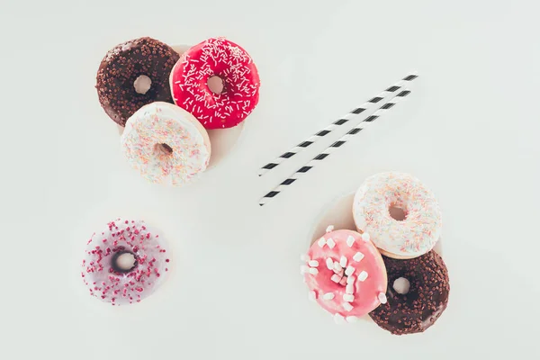Vista superior de vários donuts saborosos na superfície branca — Fotografia de Stock