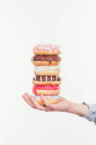 Tiro recortado de mujer sosteniendo pila de sabrosas rosquillas aisladas en blanco - foto de stock