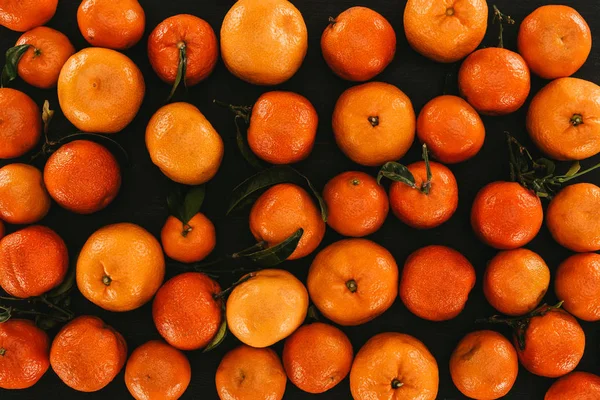 Marco completo sobre mandarinas maduras con hojas aisladas en negro - foto de stock