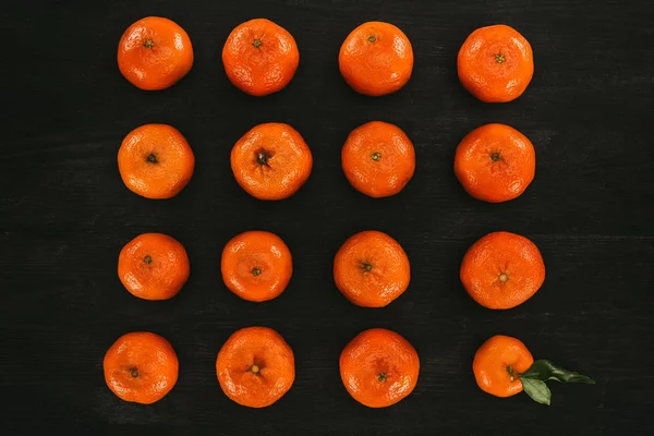 Vista superior de mandarinas dispuestas sobre superficie de madera negra - foto de stock
