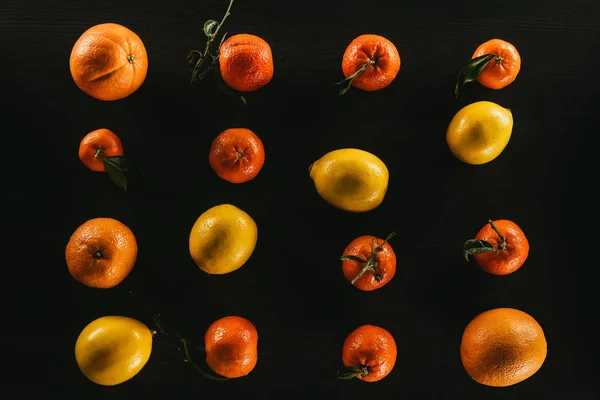 Плоский лежал с спелыми лимонами и мандаринами изолированы на черном — стоковое фото