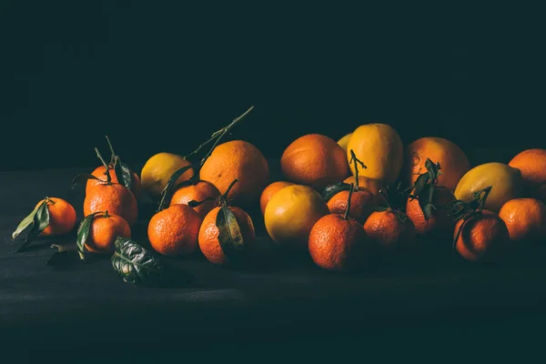Закрыть вид спелых мандаринов и лимонов на деревянный стол — стоковое фото