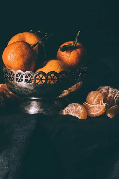 Vista de perto de tangerinas frescas em tigela de metal na mesa com toalha de mesa escura — Fotografia de Stock