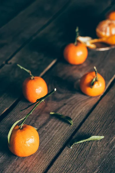 Vista de perto de tangerinas maduras com folhas na mesa de madeira — Fotografia de Stock