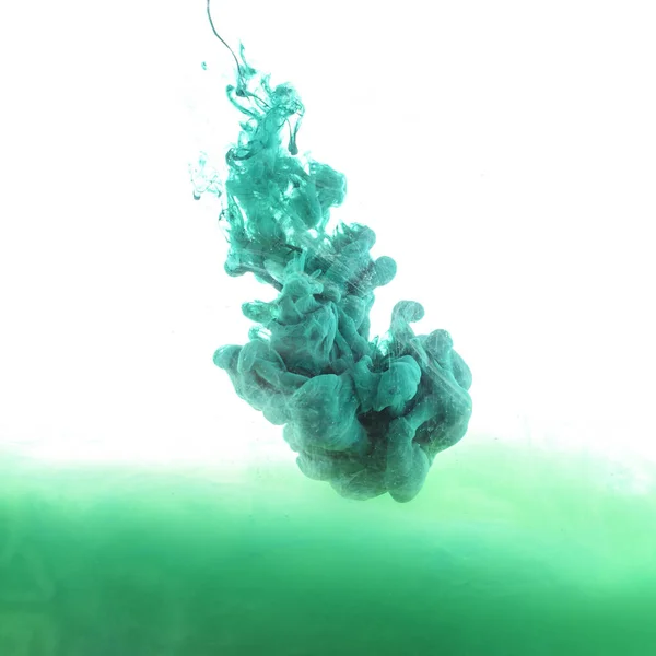 Крупним планом вид змішування зеленої і синьої фарби бризки ізольовані на білому — стокове фото