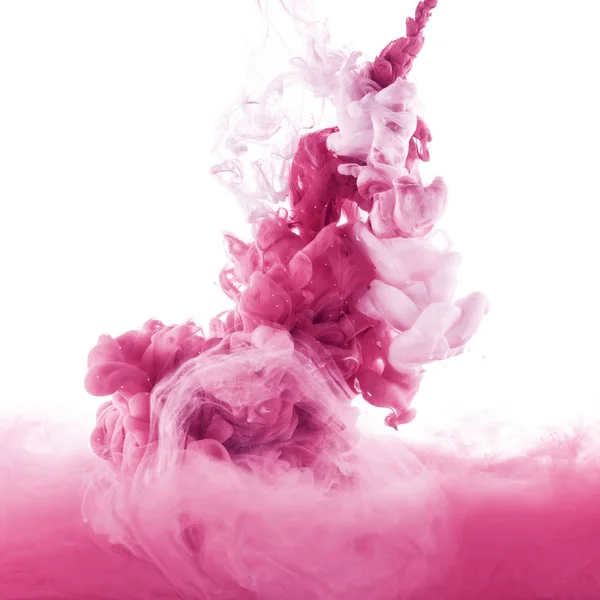 Vue rapprochée des éclaboussures de peinture rose et rose clair dans l'eau, isolées sur blanc — Photo de stock