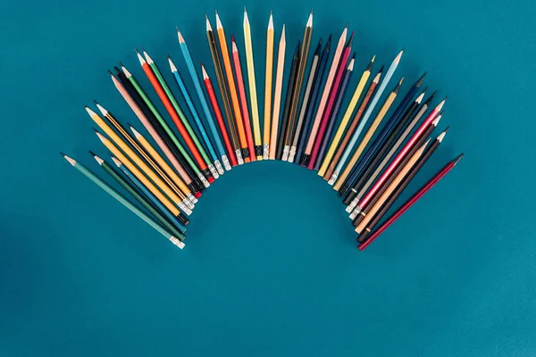 Ansicht von oben der Zusammensetzung der Buntstifte isoliert auf blauem Hintergrund — Stockfoto