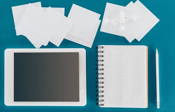 Top view of tablet with blank screen with blank papers and pen isolated on blue — Stock Photo