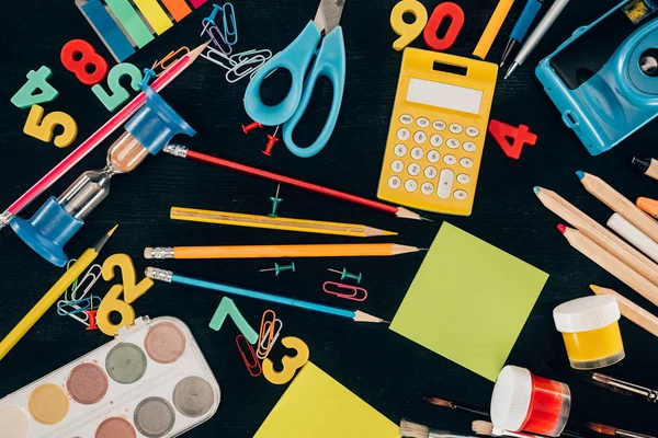 Top view of composition of colorful school supplies isolated on dark board background — Stock Photo