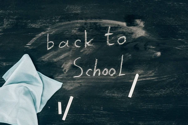 Top view of Back to school inscription on chalk board with cloth — Stock Photo