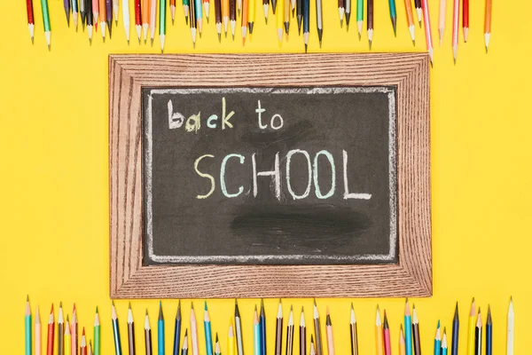 Top view of Back to school inscription on chalk board with pencils — Stock Photo