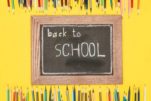 Vue du dessus de l'inscription Retour à l'école sur un tableau à crayons — Photo de stock