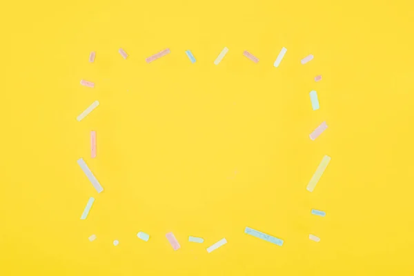 Верхний вид рамки из разноцветных меловых выделенных на желтом фоне — стоковое фото