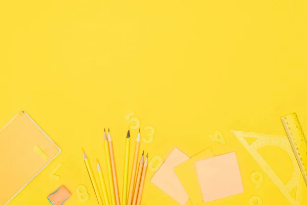 Vue du dessus de la composition des fournitures scolaires colorées isolées sur fond jaune — Photo de stock