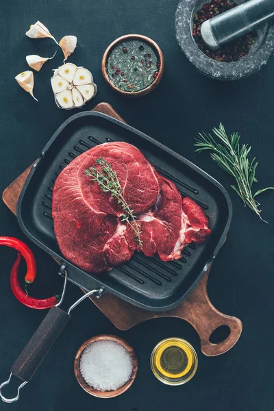 Vista superior de bife na panela de grelha com vários temperos ao redor — Fotografia de Stock