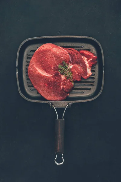 Draufsicht auf rohes Steak mit Kräutern auf Grillpfanne — Stockfoto