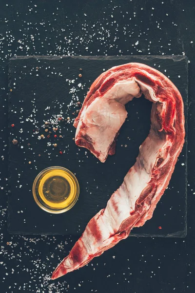 Top view of raw ribs slice with bowl of oil and spices around — Stock Photo